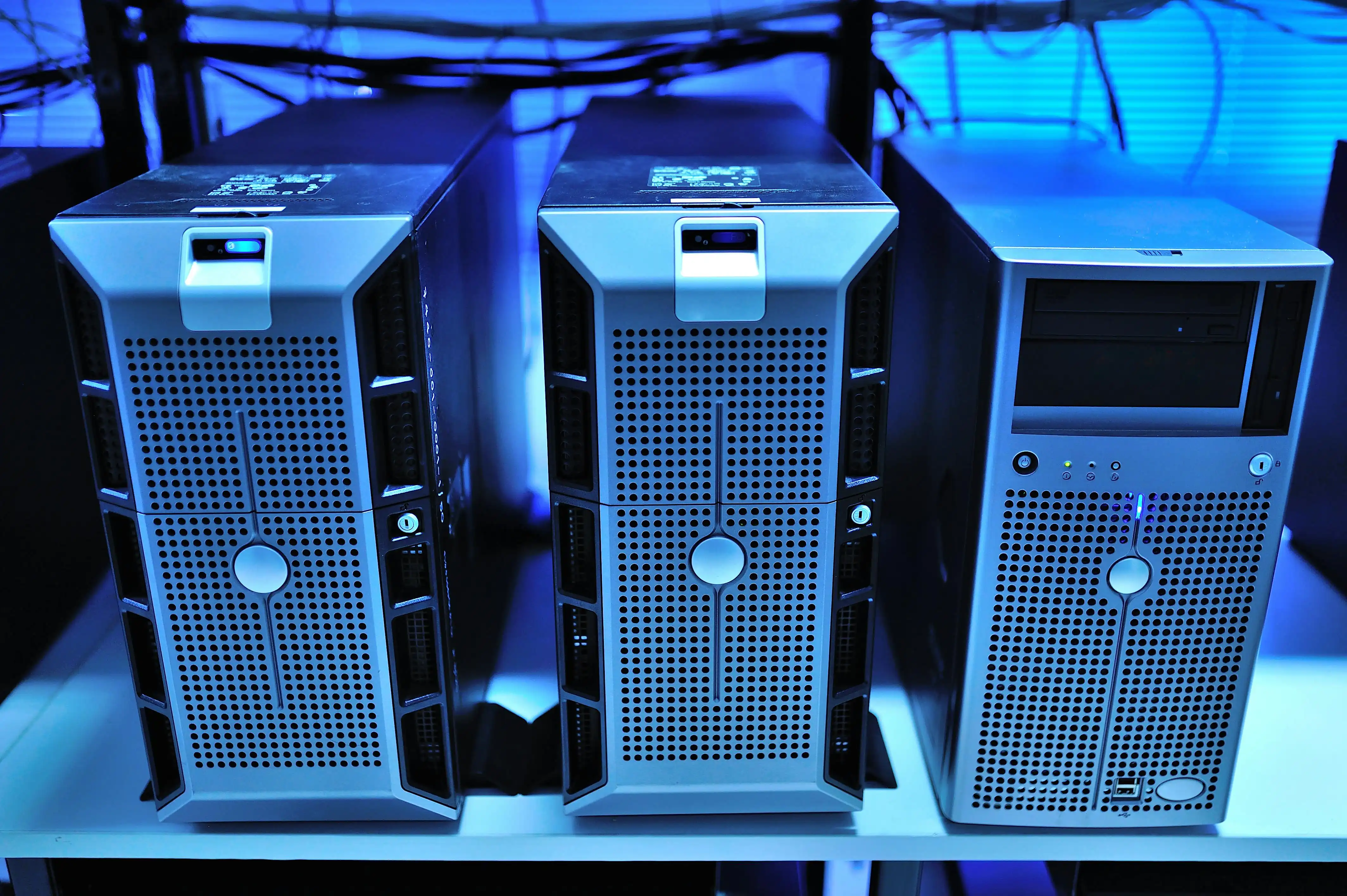 Three enterprise tower servers under blue lighting.