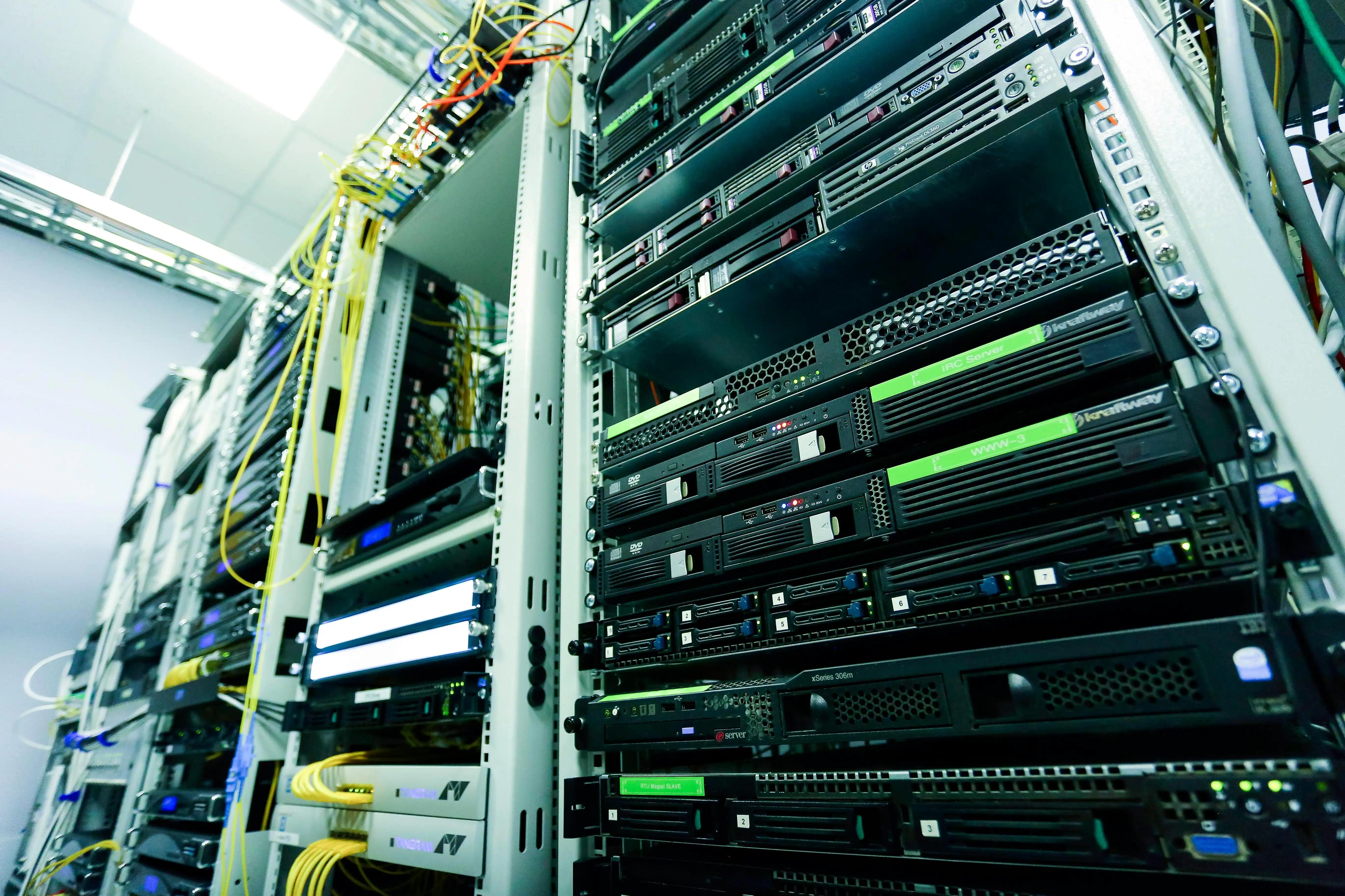 A populated server rack with cabling and rows of green status lights.